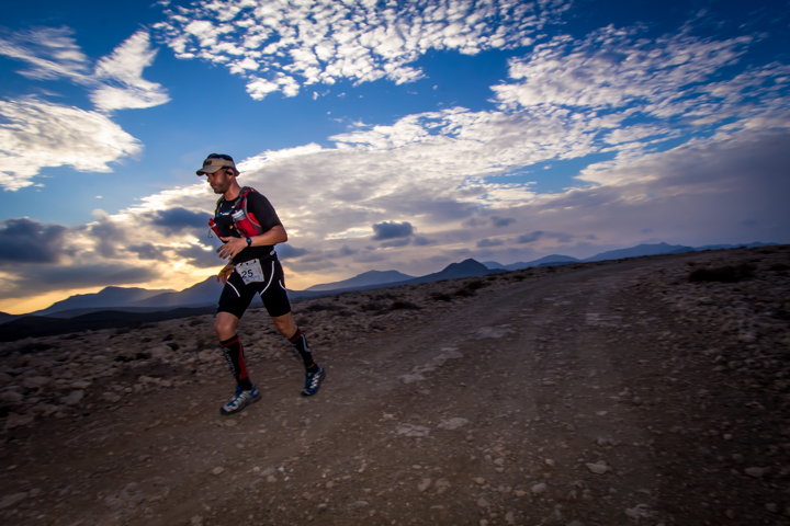 Trail runner in Fuerteventura beneath an evening sky