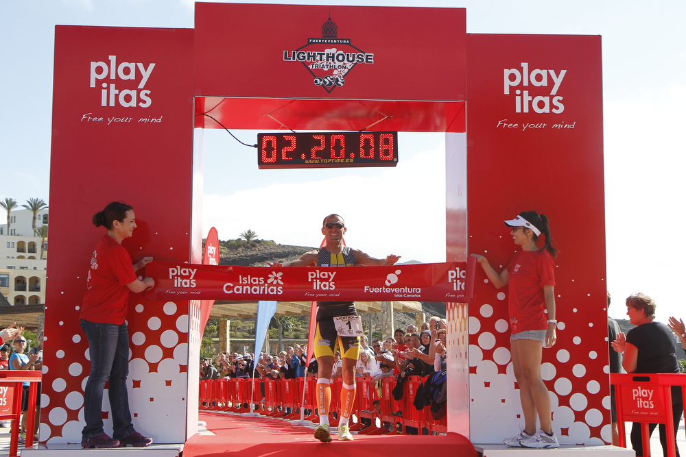 Triathlete crossing the Lighthouse Classic Triathlon finish line