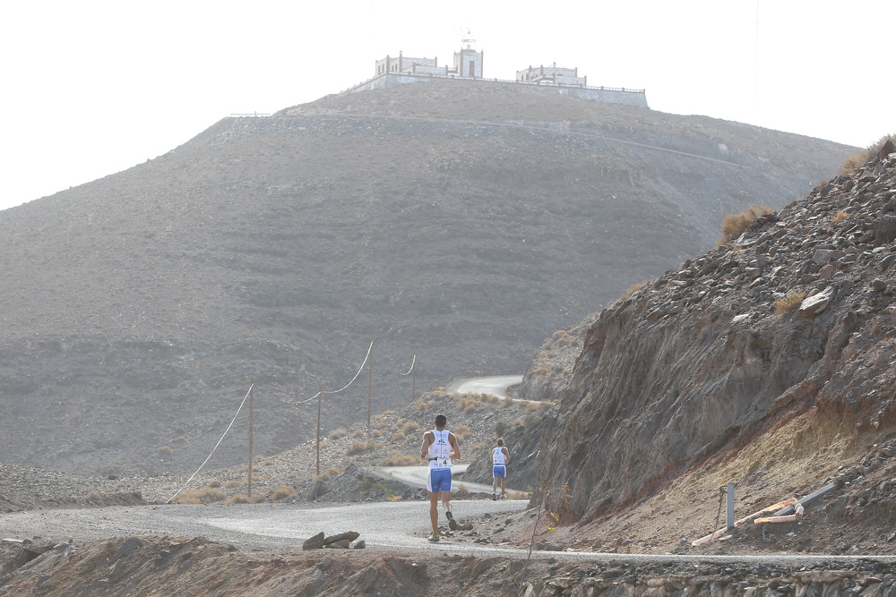 Two runners climbing the road towards Faro de la Entallada